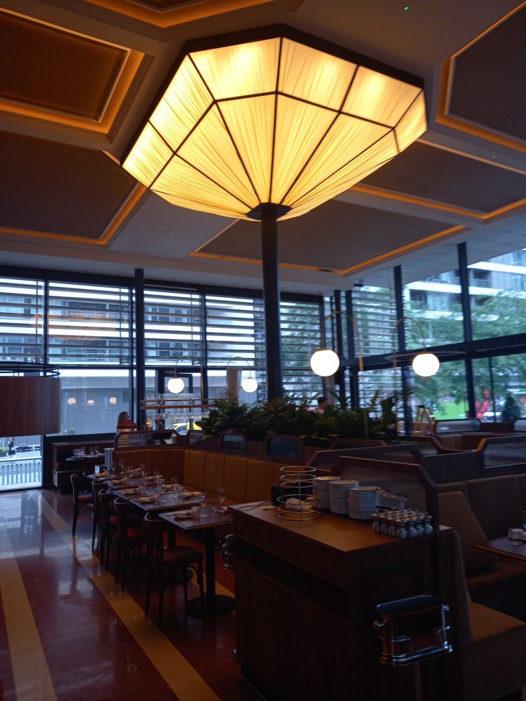Bespoke pleated feature ceiling light in a restaurant, hanging above the dining room