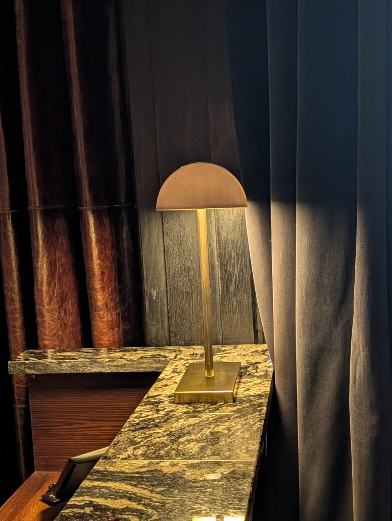 Antique brass counter lamp lighting a marble maître d' stand